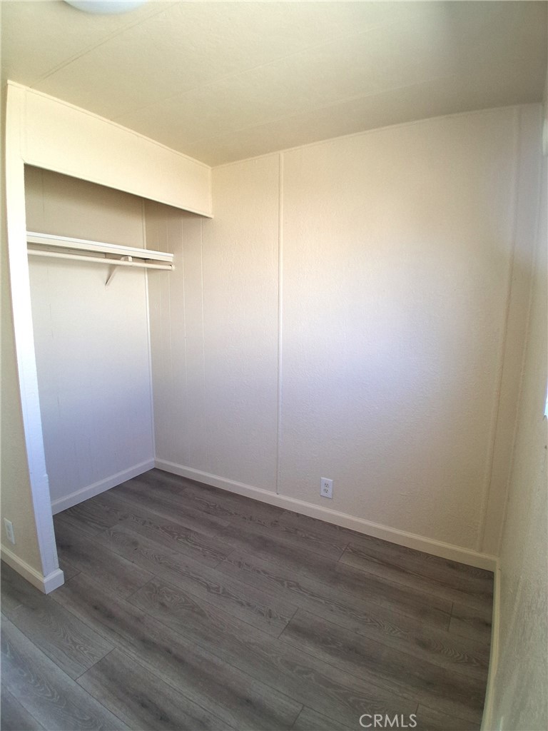 4561 Adobe Road, Unit 40 Twentynine Palms, CA 92277 - Photo 22 of 29 an empty room with wooden floor and sliding door