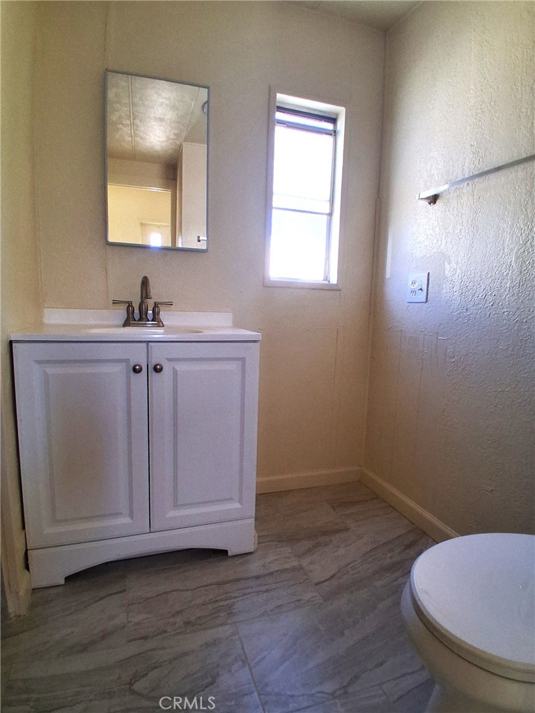 4561 Adobe Road, Unit 40 Twentynine Palms, CA 92277 - Photo 25 of 29 a bathroom with a sink a toilet and a mirror