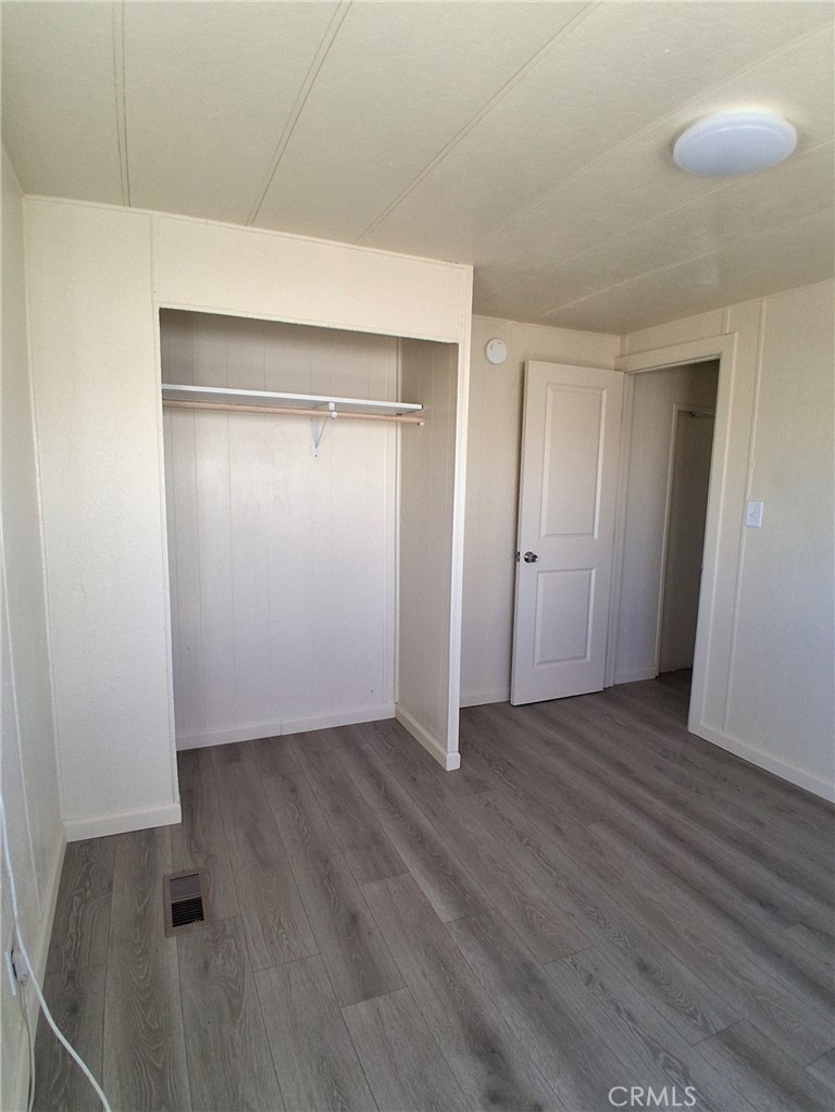 4561 Adobe Road, Unit 40 Twentynine Palms, CA 92277 - Photo 29 of 29 an empty room with wooden floor and closet
