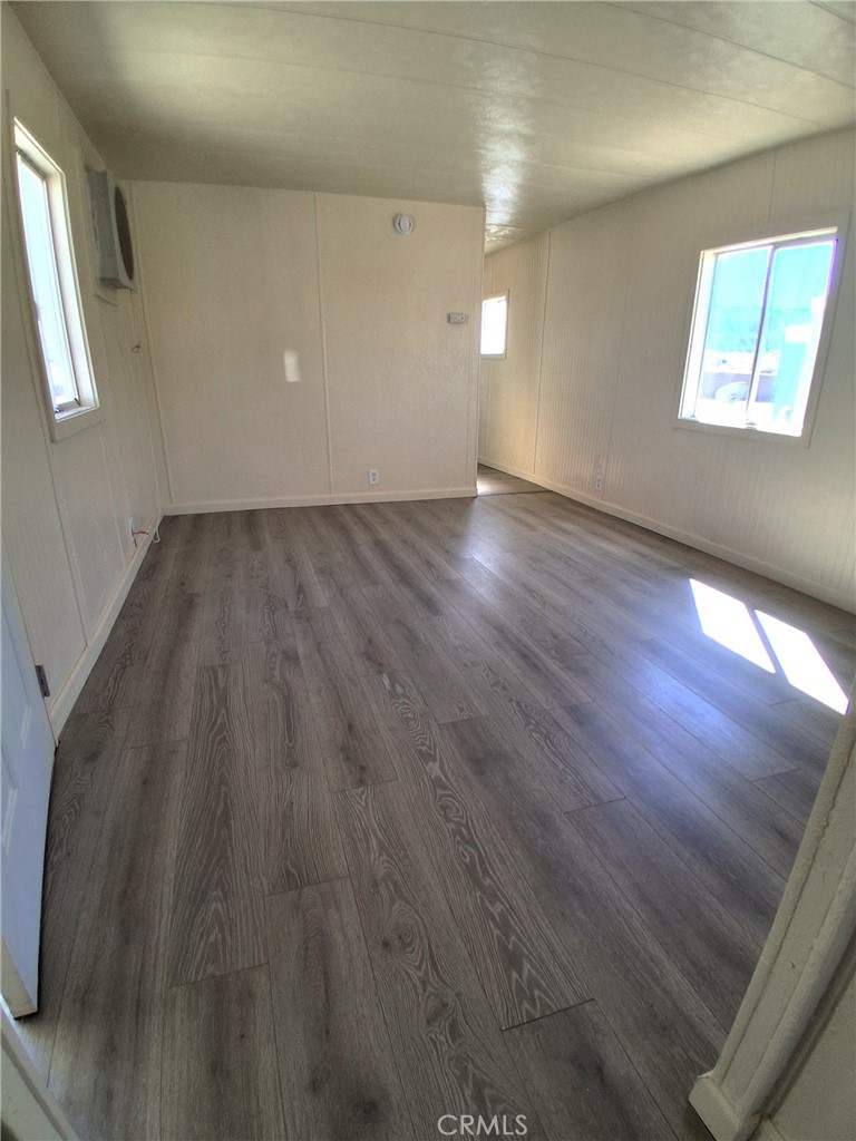 4561 Adobe Road, Unit 40 Twentynine Palms, CA 92277 - Photo 9 of 29 an empty room with wooden floor and windows