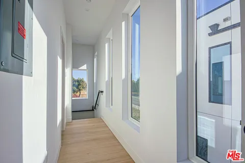 a view of a hallway with a livingroom and a bathroom with sink