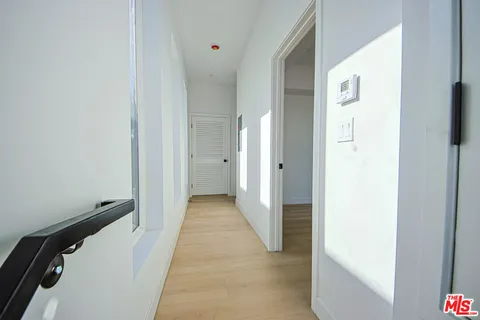 a view of a hallway with wooden floor