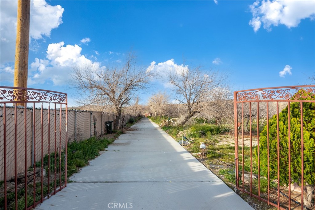 31516 Clay River Road Barstow, CA 92311 - Photo 3 of 73 a view of a pathway with a wrought fence