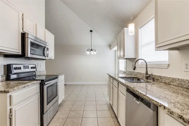 a kitchen with stainless steel appliances granite countertop a sink stove and cabinets