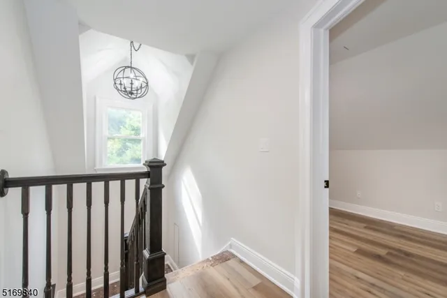 a view of a hallway with wooden floor and a window
