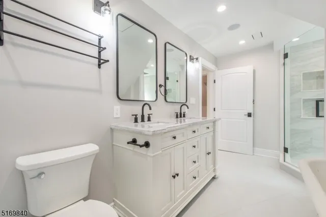 a bathroom with a double vanity sink mirror and toilet