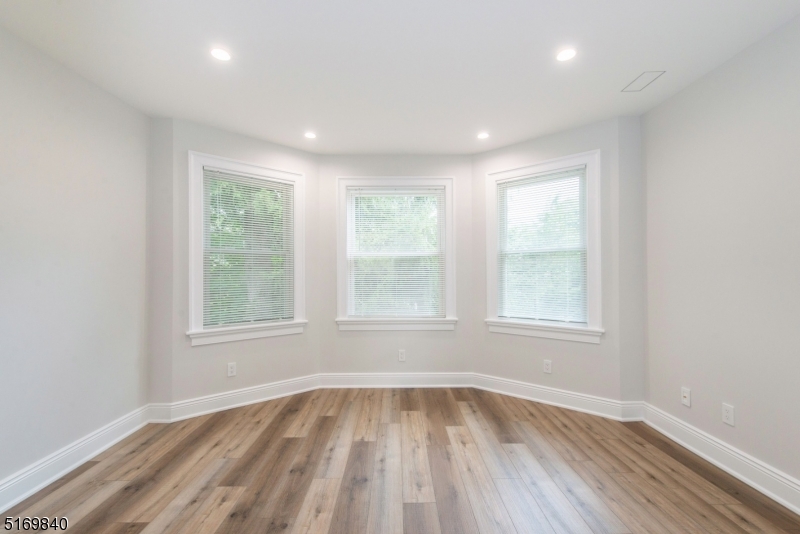 31-37 Oak Grove Road, Unit 2 Caldwell, NJ 07006 - Photo 7 of 34 an empty room with wooden floor and windows