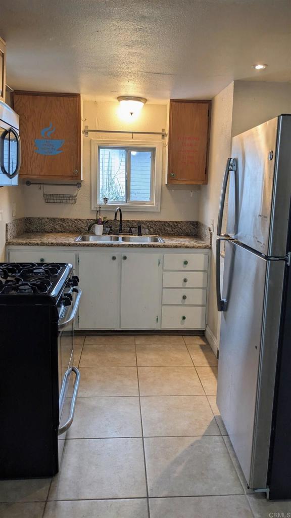 3258 Tyler Street Carlsbad, CA 92008 - Photo 3 of 27 a kitchen with granite countertop a refrigerator and a sink
