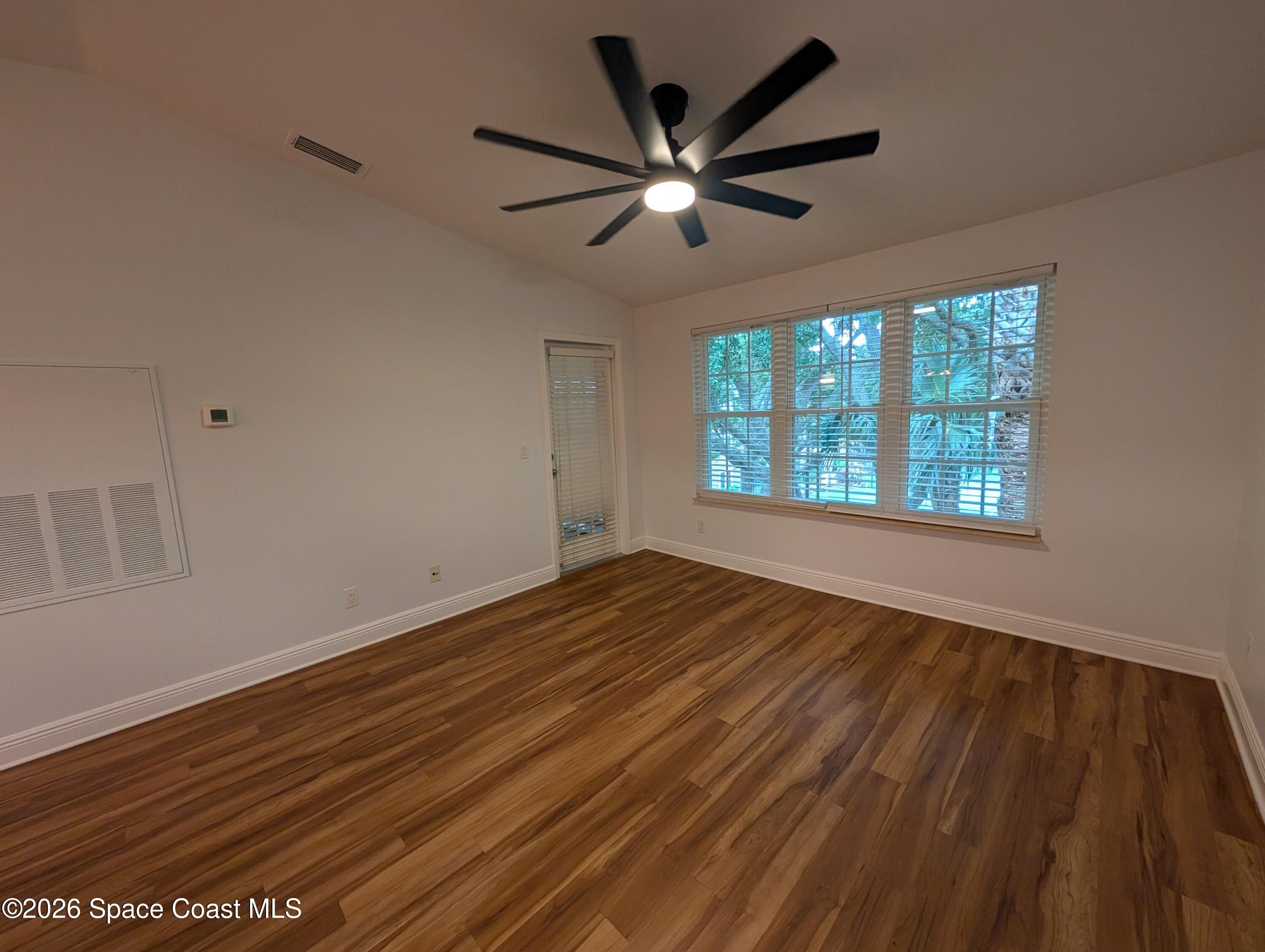 7667 North Wickham Road, Unit 818 Melbourne, FL 32940 - Photo 4 of 29 a view of an empty room with wooden floor and a window