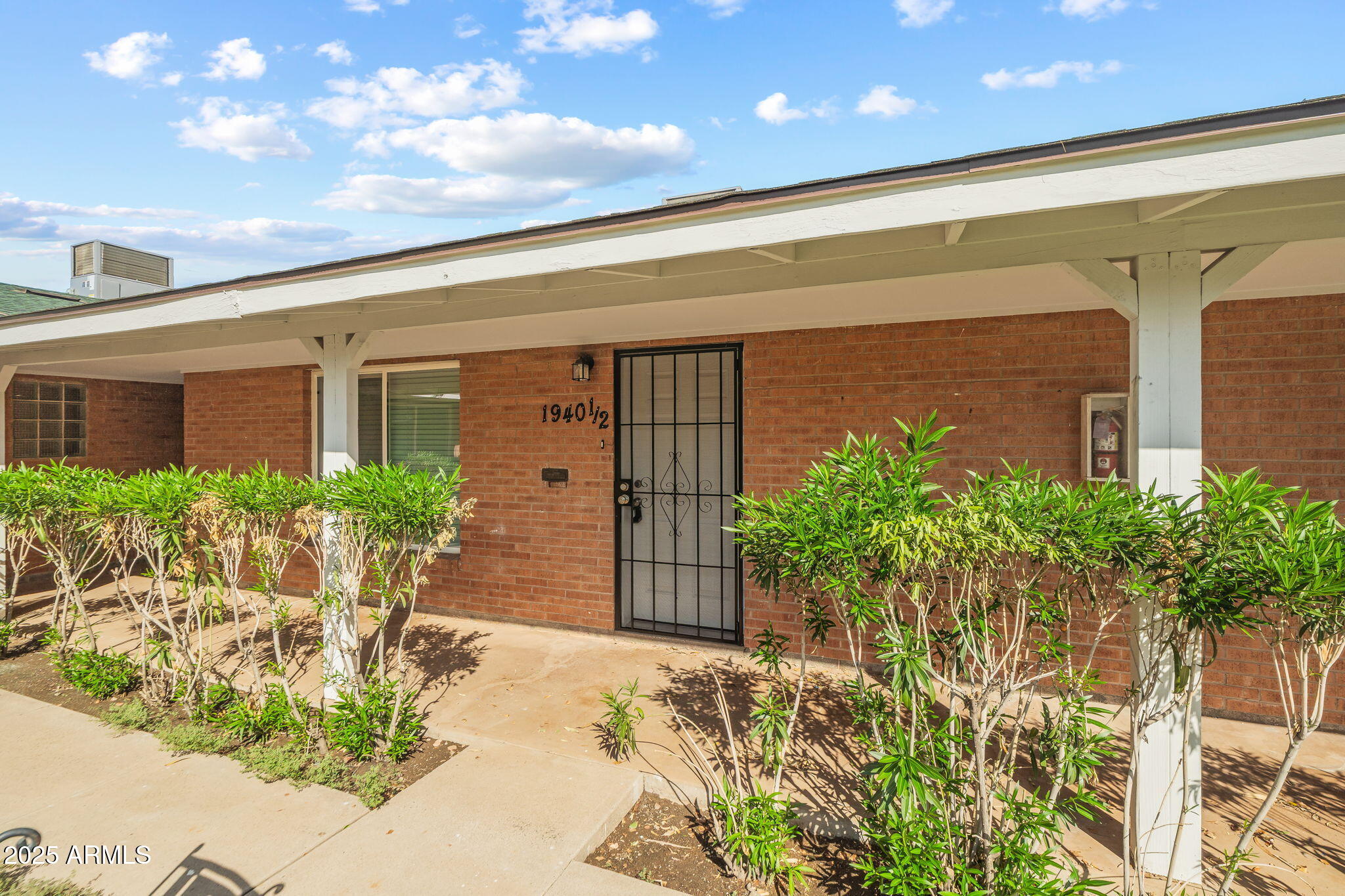 1940 West Amelia Avenue, Unit 1940 5 Phoenix, AZ 85015 - Photo 3 of 14 a front view of a house with a yard and plant in front of it