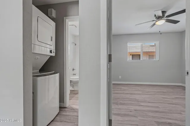 a view of an empty room with closet and a ceiling fan