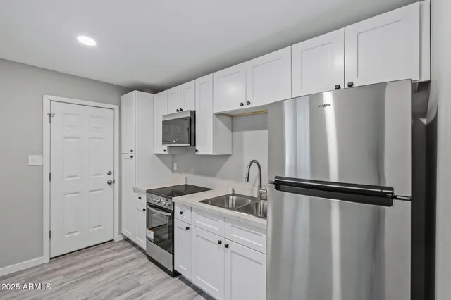 a kitchen with stainless steel appliances refrigerator sink and cabinets