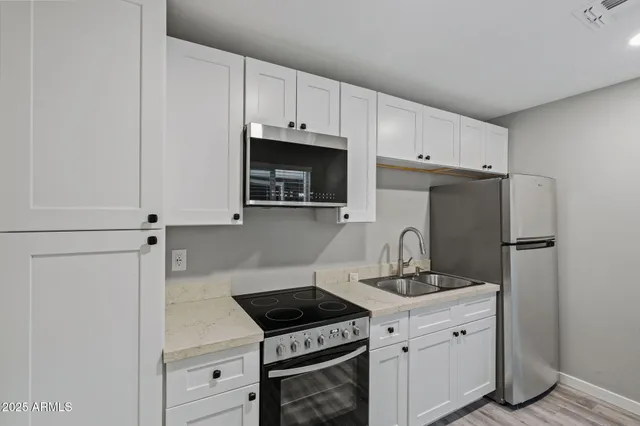 a kitchen with appliances a sink and cabinets