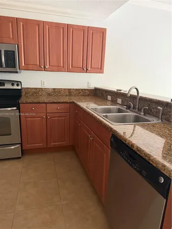 a kitchen with granite countertop a sink stove and cabinets