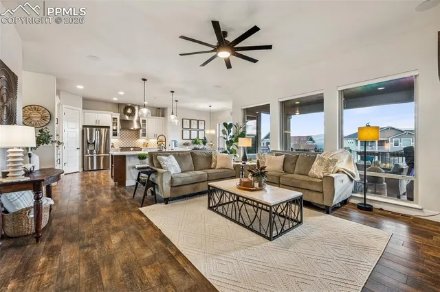 a living room with furniture kitchen view and a large window