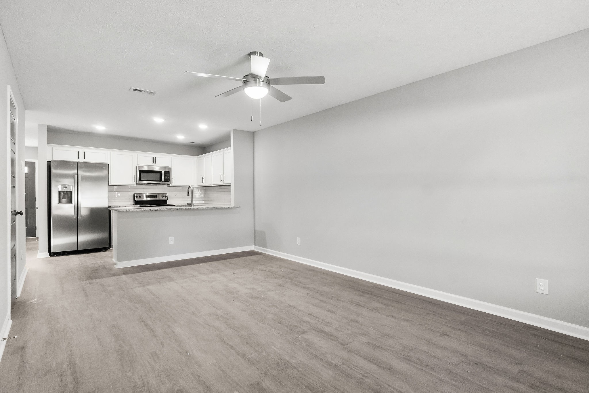 a view of a kitchen with a sink and dishwasher a refrigerator with wooden floor