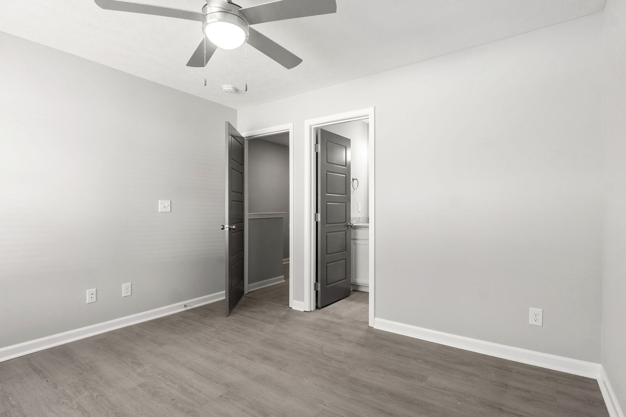 303 Longshadow Trail, Unit E Clarksville, TN 37043 - Photo 18 of 29 an empty room with a ceiling fan and wooden floor