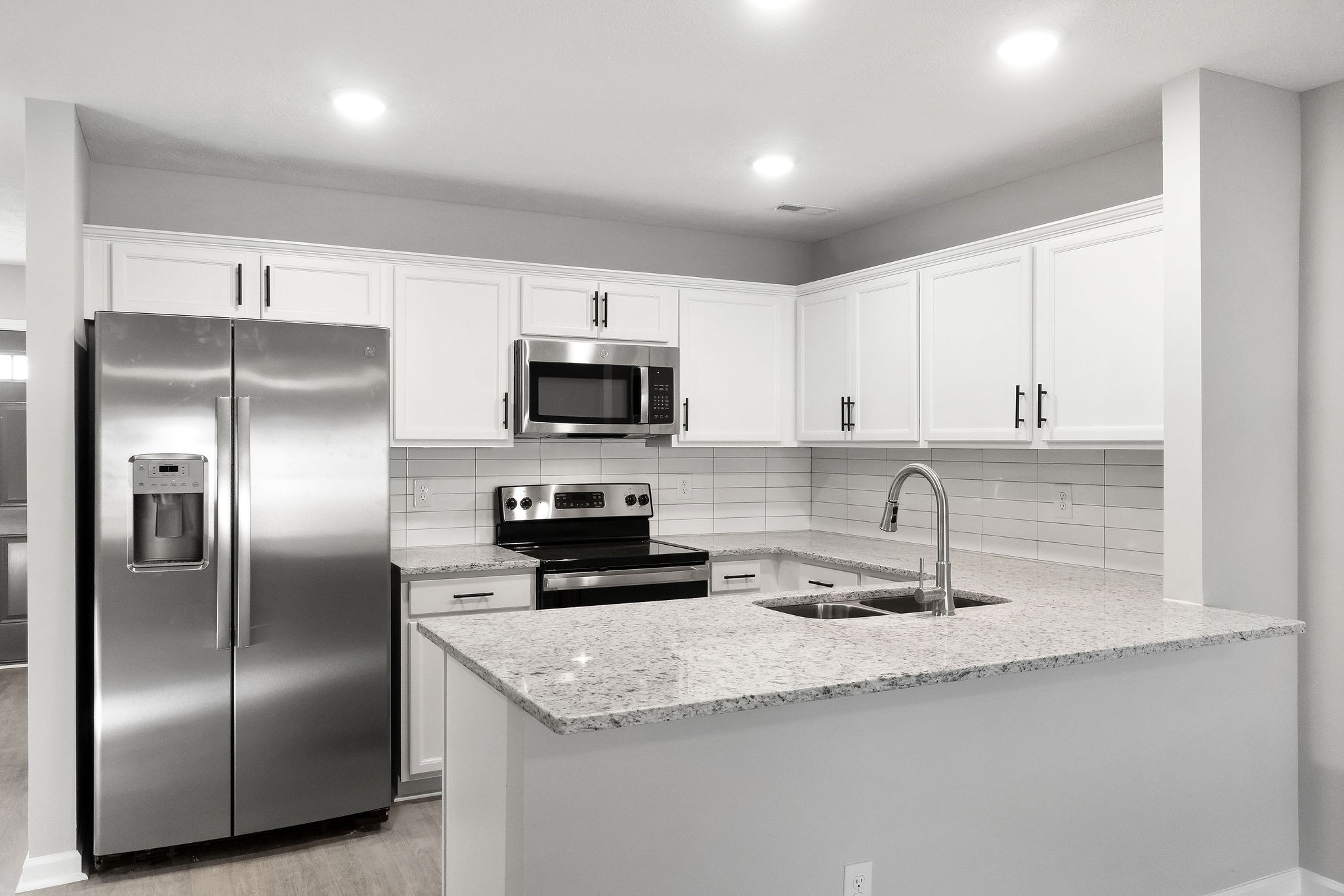 303 Longshadow Trail, Unit E Clarksville, TN 37043 - Photo 4 of 29 a kitchen with kitchen island granite countertop a refrigerator a sink a stove a microwave and cabinets