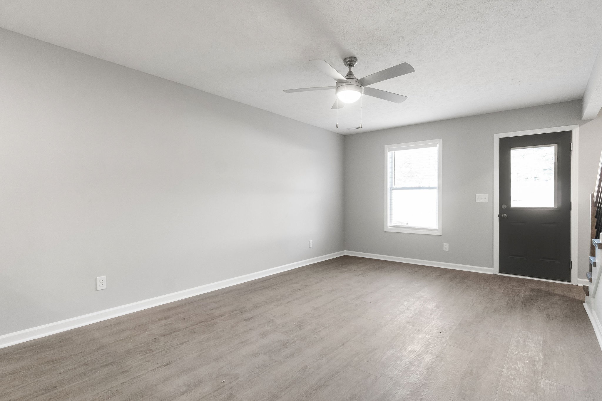 303 Longshadow Trail, Unit E Clarksville, TN 37043 - Photo 8 of 29 an empty room with wooden floor fan and windows
