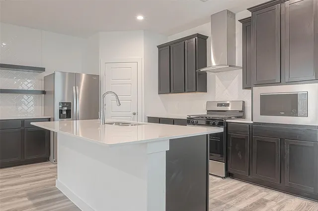 a kitchen with stainless steel appliances a sink stove and refrigerator