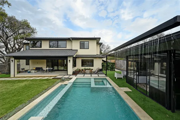 a view of house with a big yard and potted plants