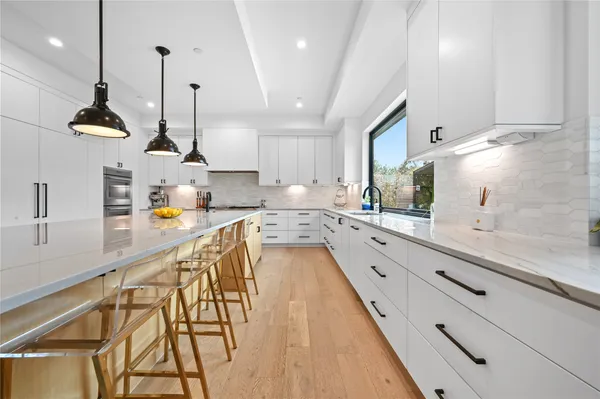 a large kitchen with kitchen island a large counter top space a sink stainless steel appliances and cabinets