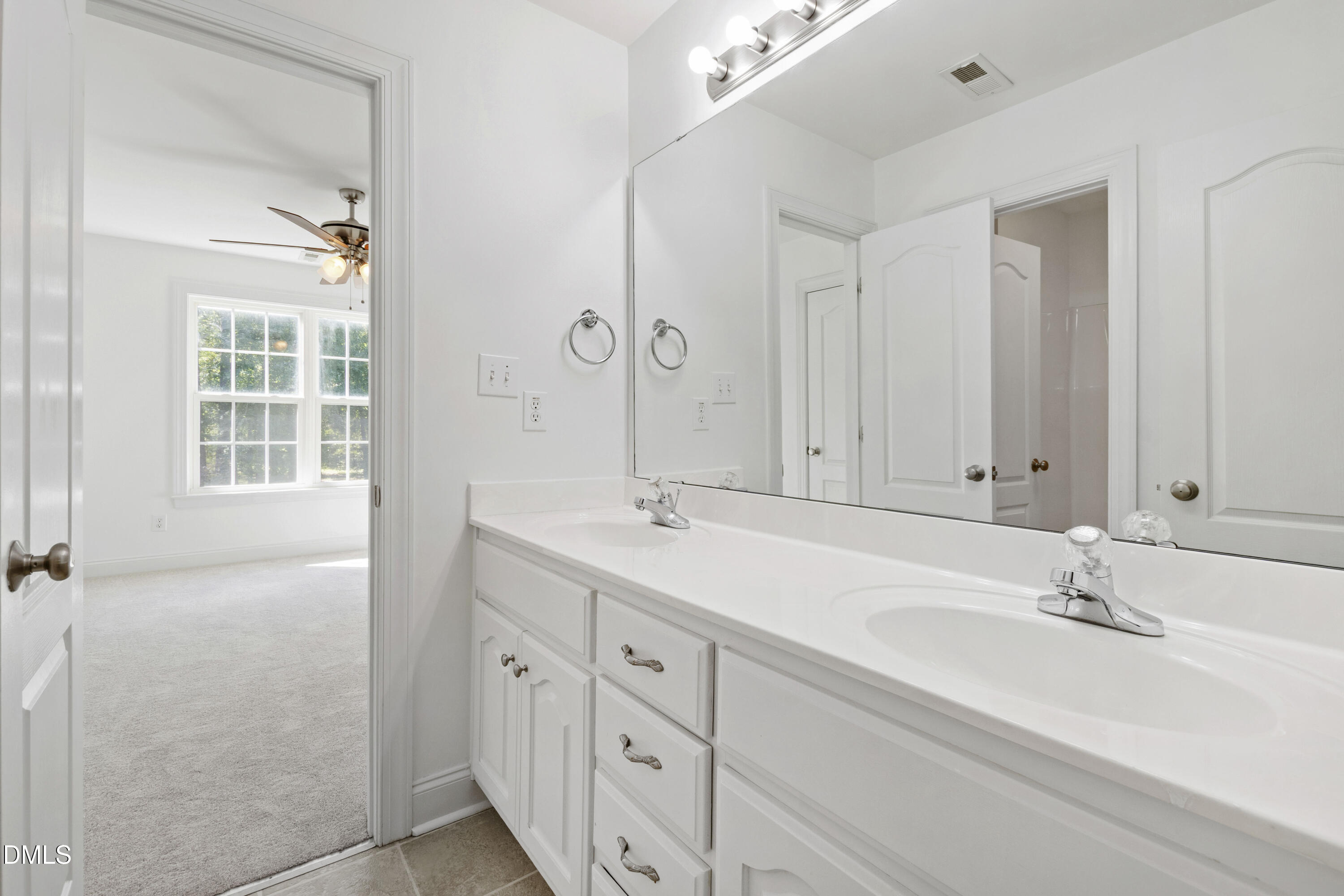 212 Fox Pen Drive Raleigh, NC 27603 - Photo 32 of 56 a bathroom with double vanity sink a mirror and a bathtub