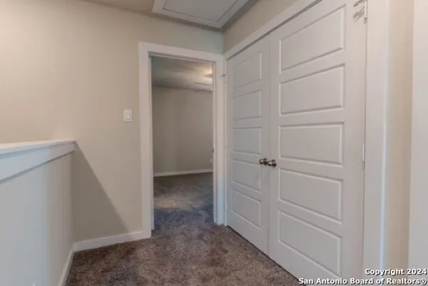 an empty room with chandelier fan and windows