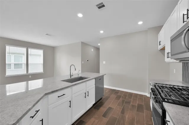 a kitchen with granite countertop a sink and dishwasher stove a refrigerator with wooden cabinets