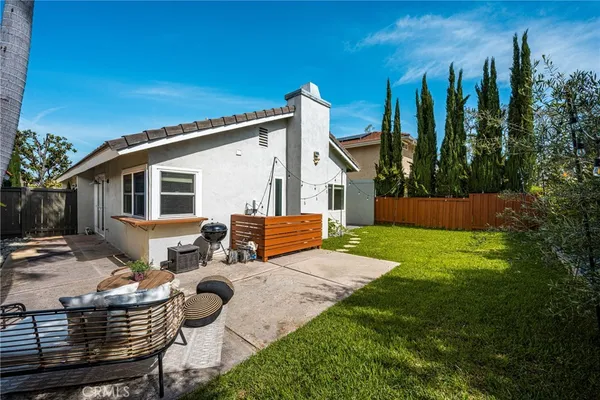 a view of a house with backyard and a tree