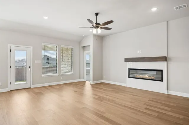 a view of an empty room with a fireplace and a window