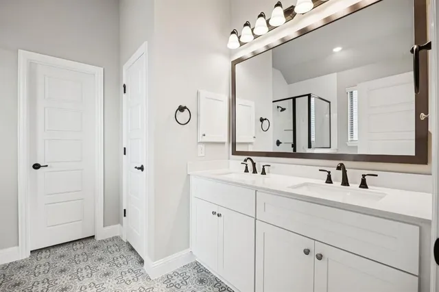 a bathroom with a double vanity sink mirror and