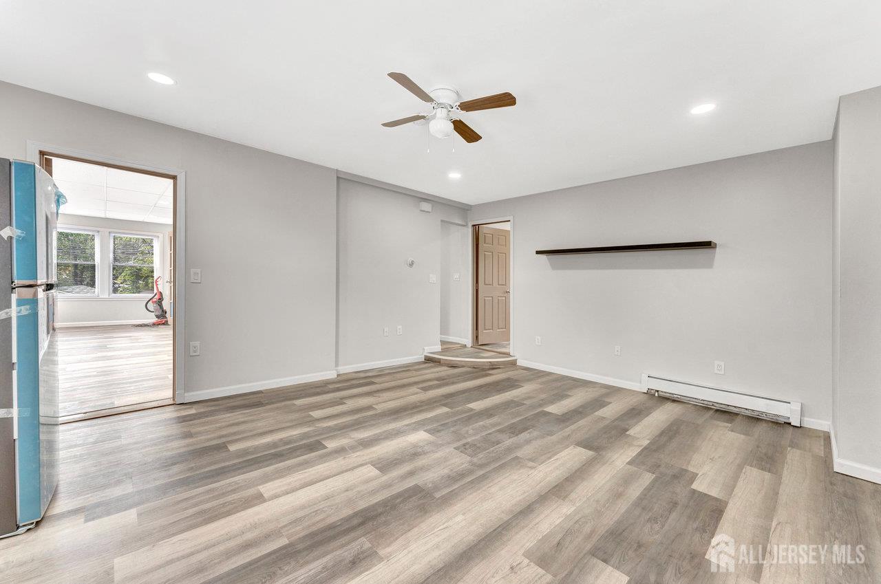 601 Ridgeway Avenue South Amboy, NJ 08879 - Photo 18 of 36 an empty room with wooden floor ceiling fan and windows