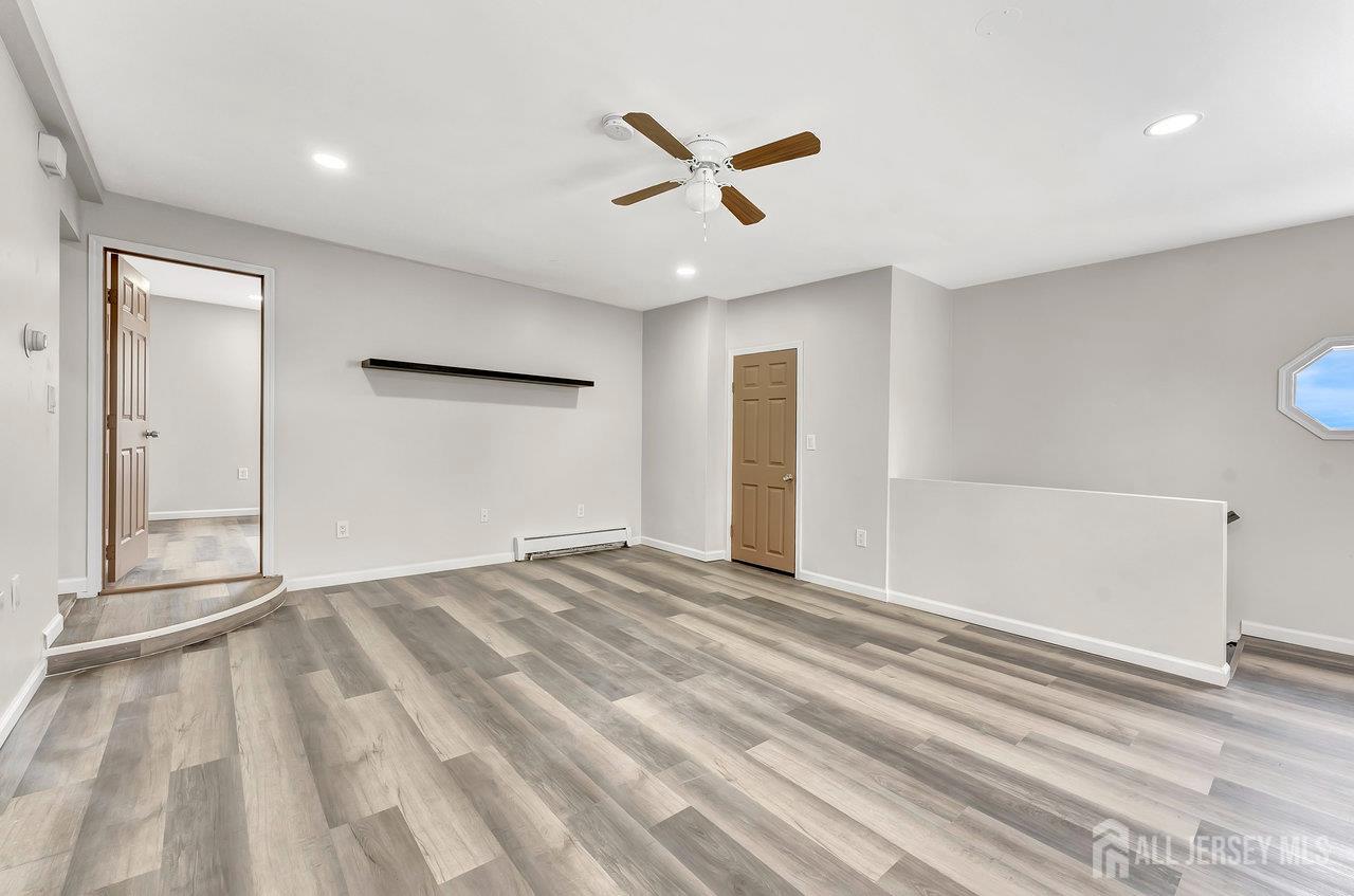 601 Ridgeway Avenue South Amboy, NJ 08879 - Photo 19 of 36 a view of an empty room with wooden floor and a ceiling fan