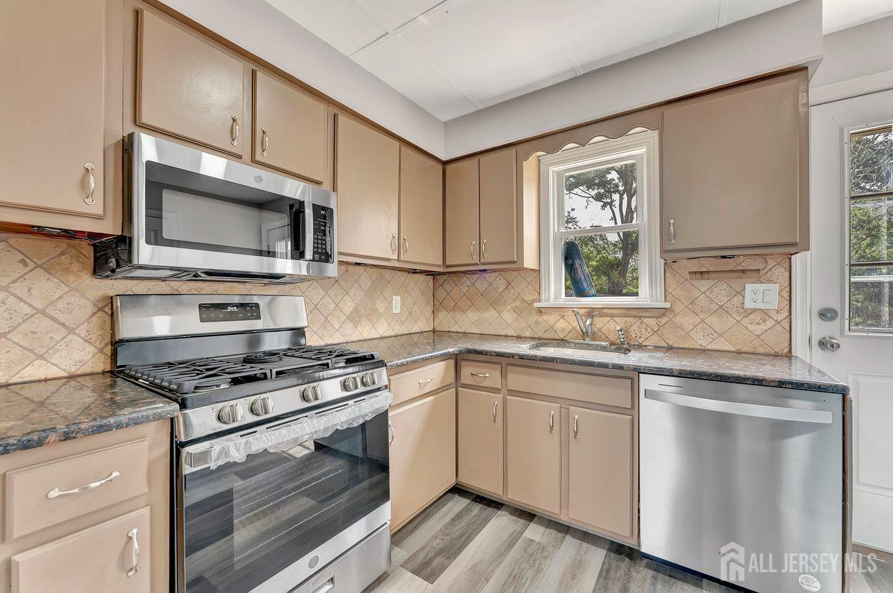 601 Ridgeway Avenue South Amboy, NJ 08879 - Photo 7 of 36 a kitchen with granite countertop a sink cabinets stainless steel appliances and a window