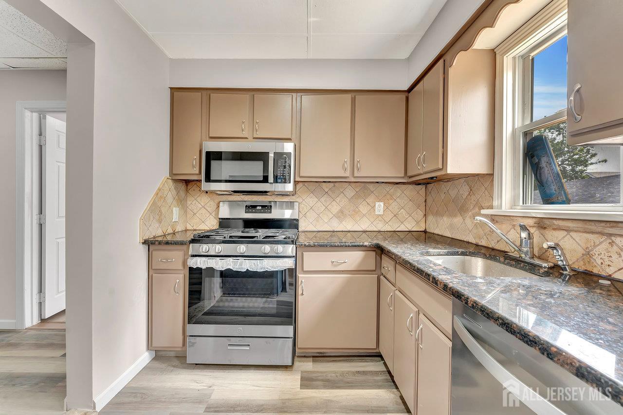 601 Ridgeway Avenue South Amboy, NJ 08879 - Photo 8 of 36 a kitchen with granite countertop a stove a sink and a microwave