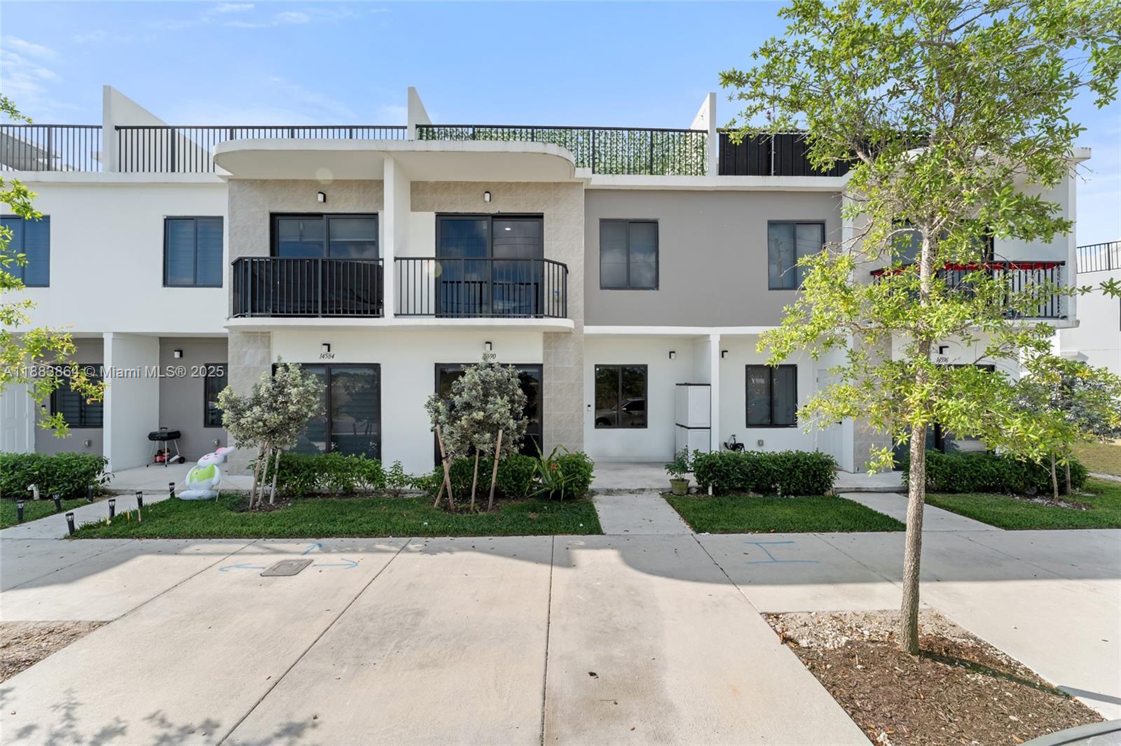 14590 Southwest 260th Street Homestead, FL 33032 - Photo 1 of 23 a front view of a house with garden