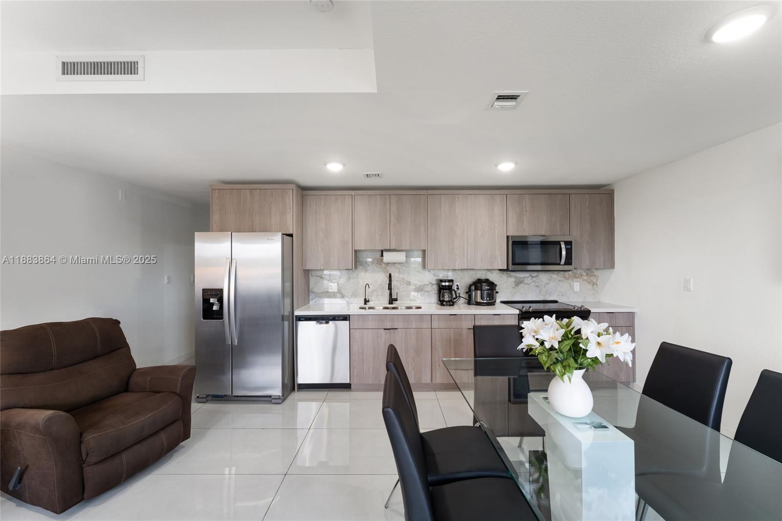 14590 Southwest 260th Street Homestead, FL 33032 - Photo 4 of 23 a kitchen with stainless steel appliances kitchen island granite countertop a refrigerator a stove a sink dishwasher and a dining table with wooden floor