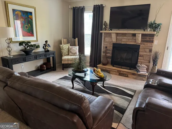a living room with furniture a flat screen tv and a fireplace