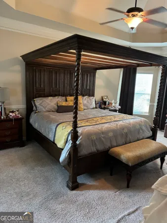 a bedroom with a bed and a ceiling fan