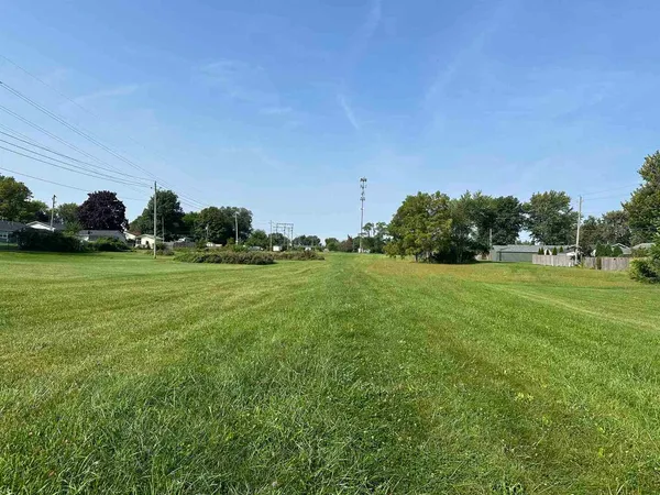 a yard with lots of green space and trees