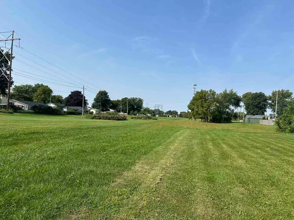 a view of a field of grass and trees