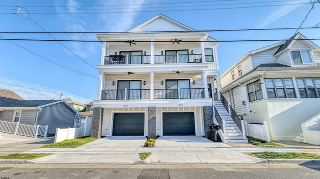 a front view of a house with yard and parking