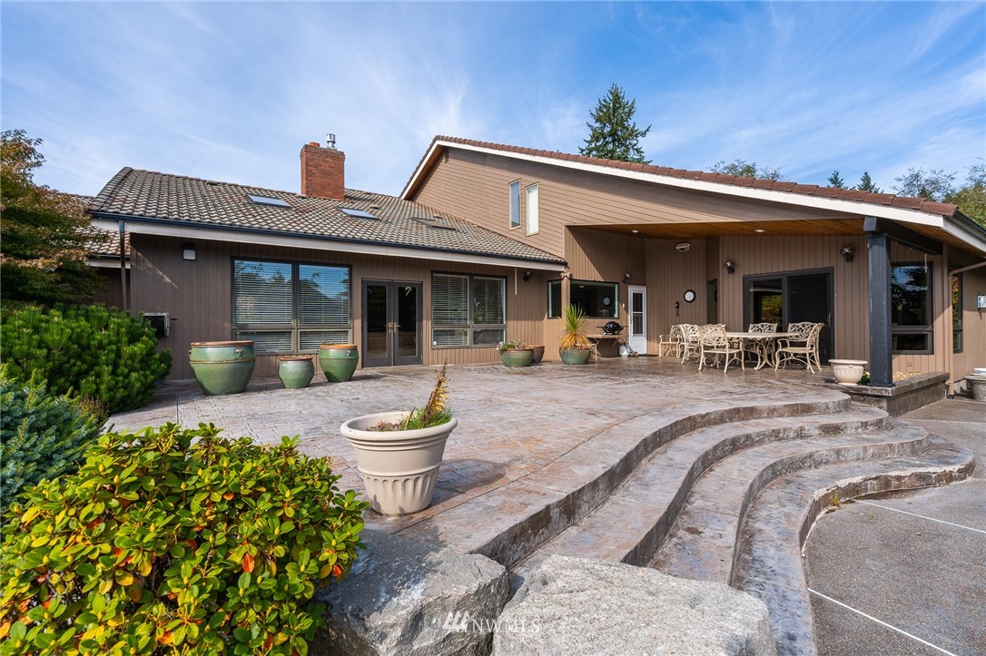 148 Taylor Road South Chehalis, WA 98532 - Photo 8 of 25 a view of a patio with table and chairs potted plants and floor to ceiling window