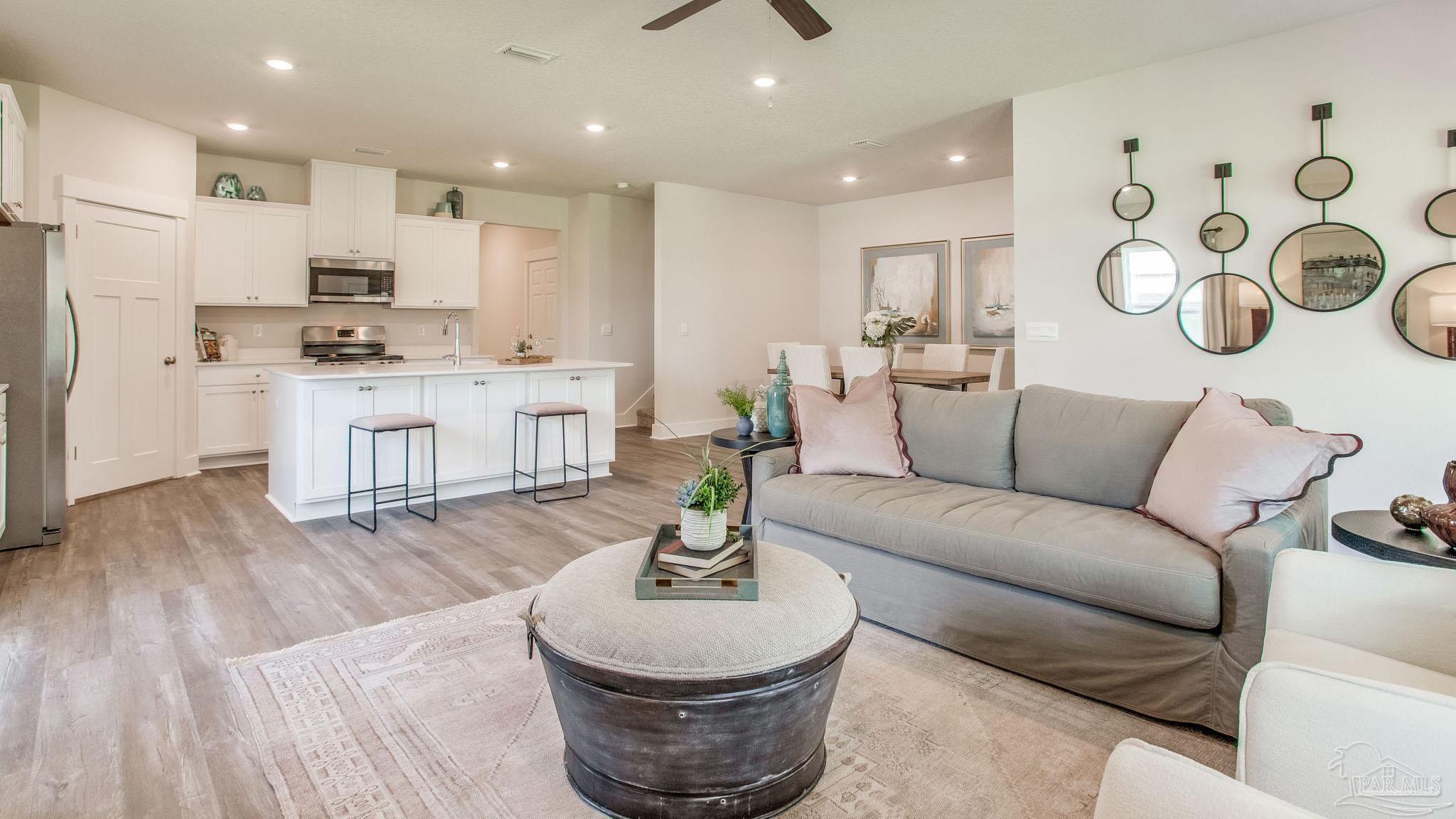 4631 Eider Road Pace, FL 32571 - Photo 14 of 46 a living room with kitchen island furniture and a wooden floor