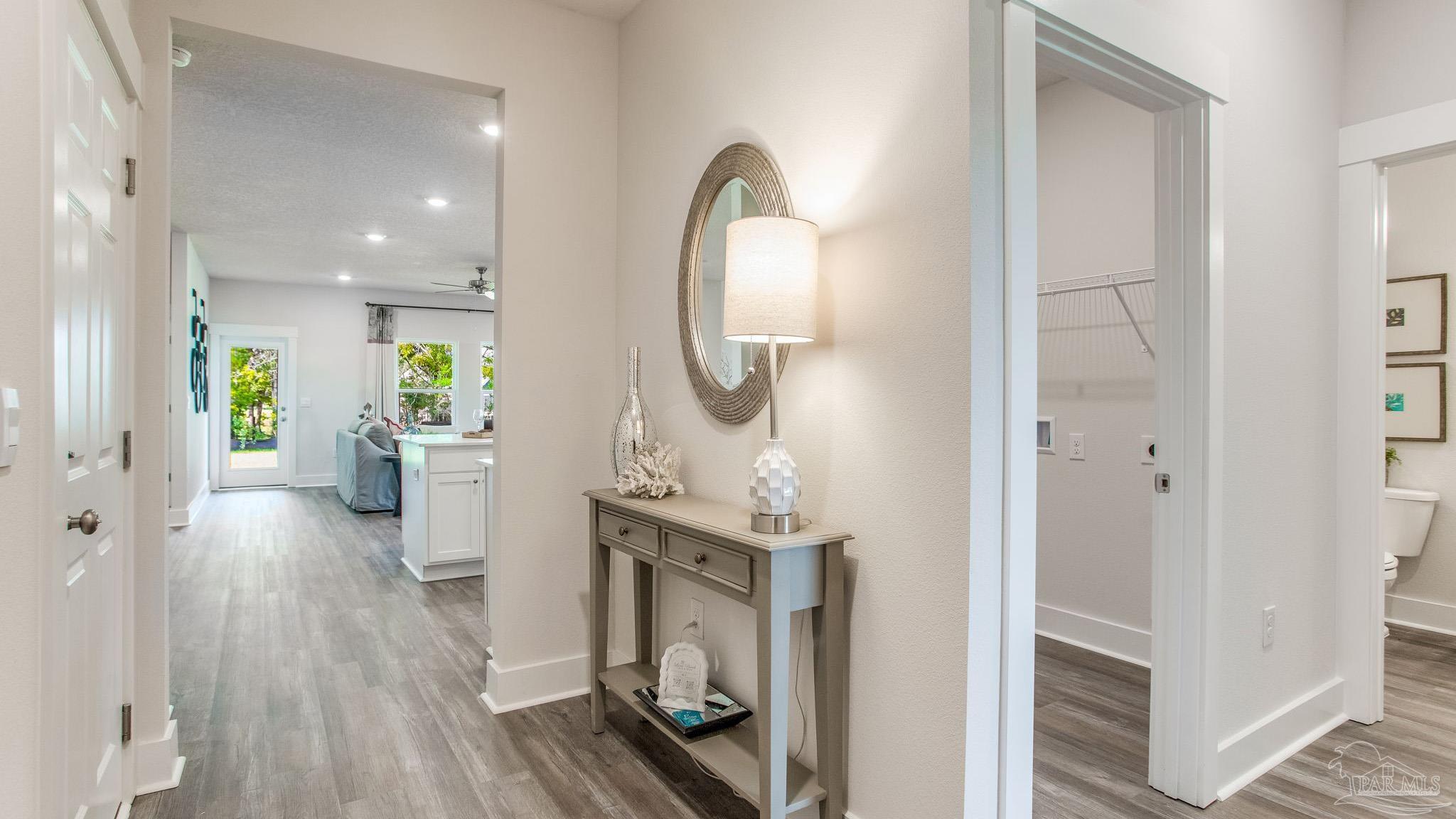 4631 Eider Road Pace, FL 32571 - Photo 25 of 46 a view of a hallway with wooden floor windows and a bathroom