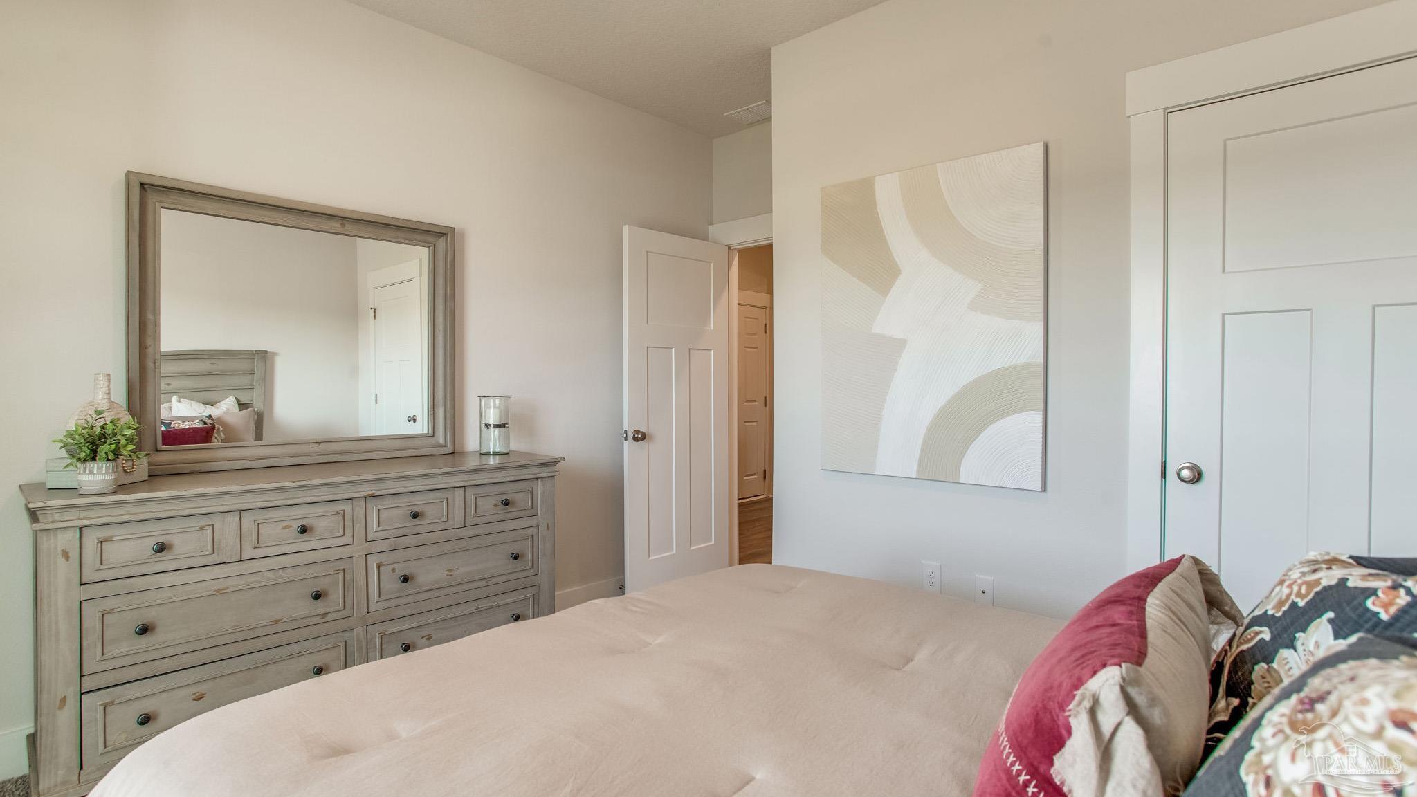 4631 Eider Road Pace, FL 32571 - Photo 27 of 46 a bedroom with a bed and a mirror on dresser