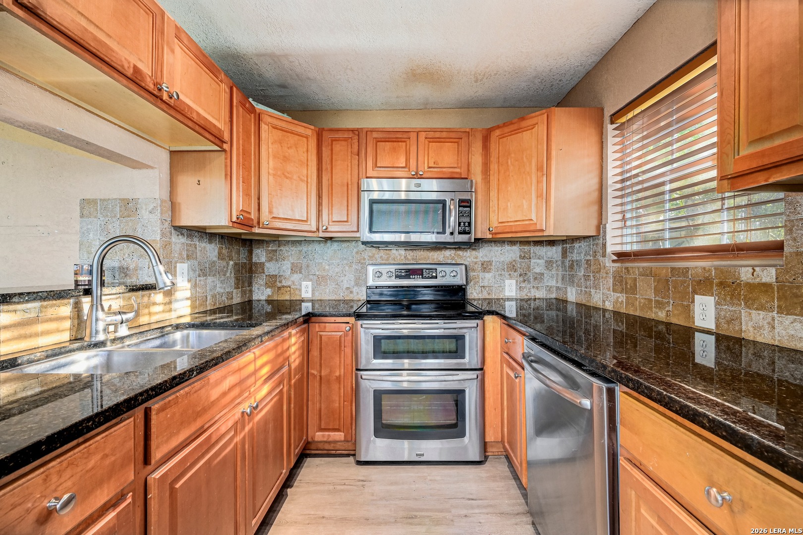 1125 Highpoint Lane Spring Branch, TX 78070 - Photo 11 of 25 a kitchen with stainless steel appliances granite countertop a stove sink and cabinets