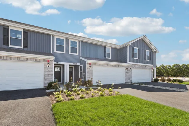 a front view of a house with a garden and yard