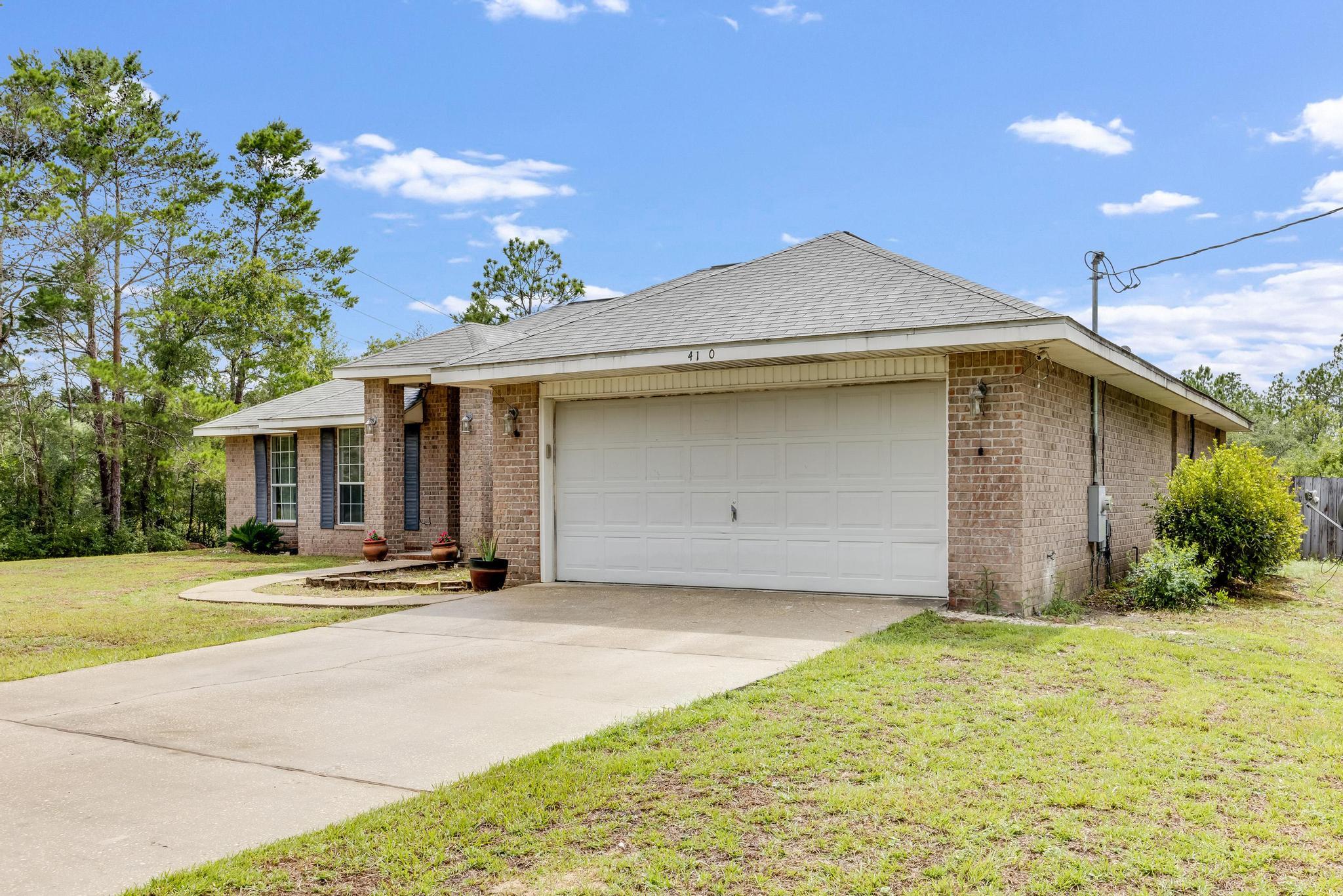 4140 Big Buck Trail Crestview, FL 32539 - Photo 2 of 40 a front view of a house with a yard and garage